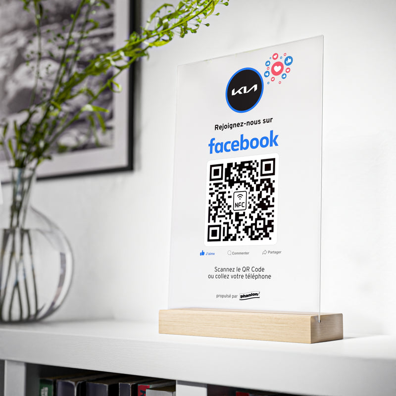 Plaque NFC QR code Facebook personnalisée en situation dans un intérieur moderne avec logo sur socle bois - Phanion