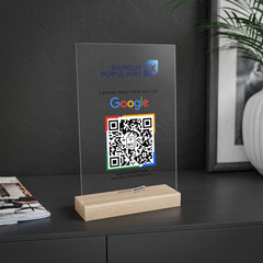 Plaque NFC QR code avis Google acrylique transparente personnalisée en situation dans un intérieur moderne avec logo et QR code couleurs sur socle bois - Phanion